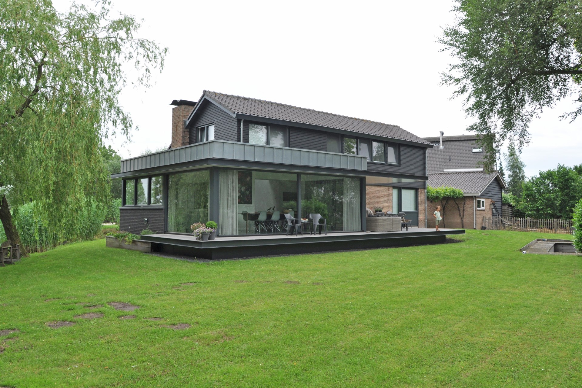 Moderne aanbouw met grote glaspuien aan bestaande woning &ndash; ontworpen door architect in Nederland