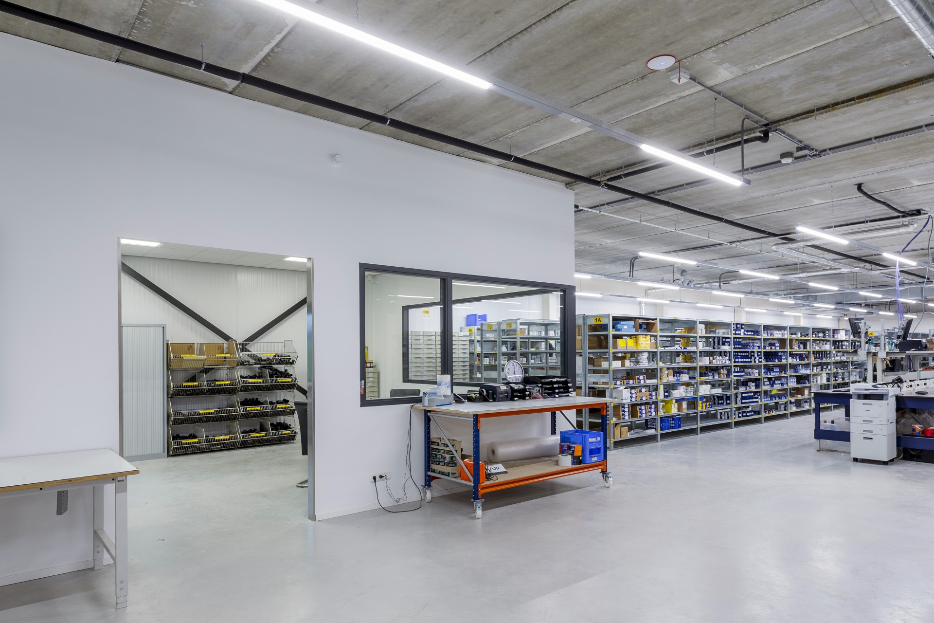 Productieruimte in modern bedrijfspand met betonnen plafond, LED-verlichting en effici&euml;nte inrichting &ndash; functioneel bedrijfspand ontwerpen