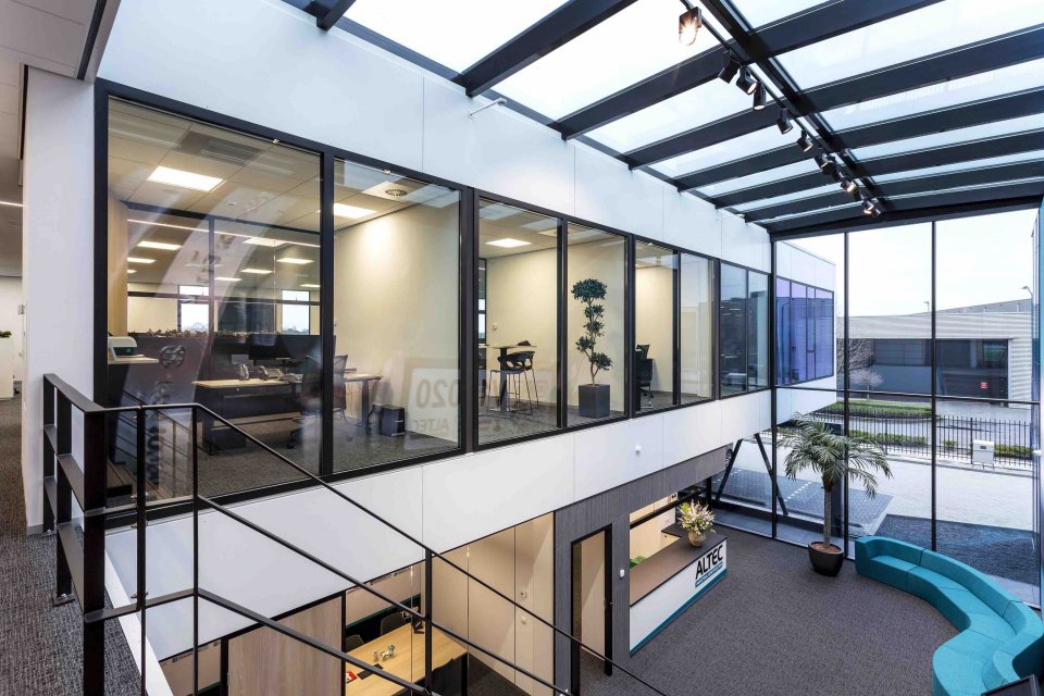 Licht atrium in modern bedrijfspand met glazen gevel en kantoorruimtes &ndash; duurzaam en functioneel ontwerp door architect Oud-Alblas.