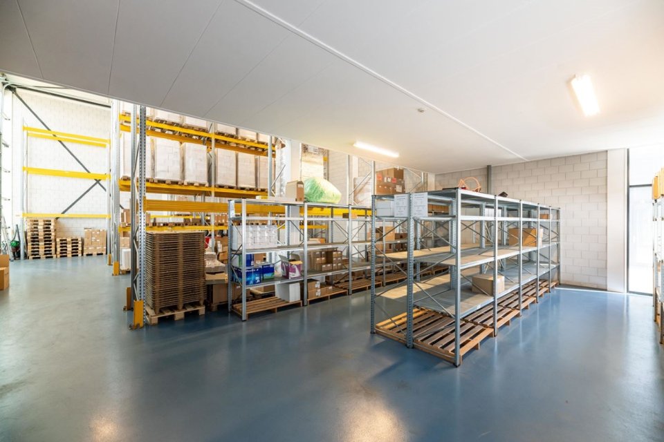 Licht en overzichtelijk magazijn met stalen stellingen en hoge ruimte &ndash; functioneel bedrijfspand ontwerpen