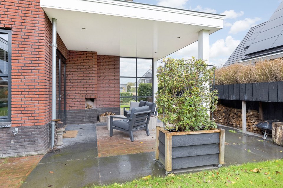 Overdekt terras met glazen hoekpui en bakstenen gevel &ndash; licht en zicht in architectuur verbinden interieur met de buitenruimte