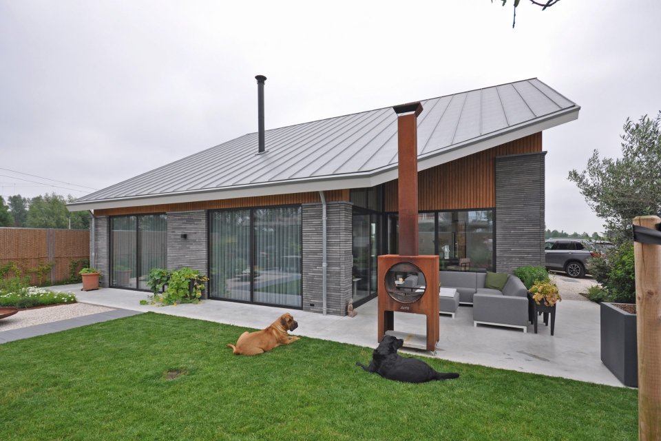 Moderne bungalow met zinken kap, donker metselwerk en grote schuifpuien &ndash; ontworpen door ervaren architectenbureau Bongers Architecten