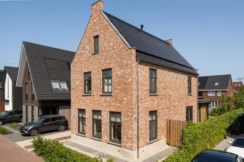 Stadswoning met klassieke bakstenen gevel, hoge ramen en zonnepanelen &ndash; duurzame nieuwbouw door Bongers Architecten