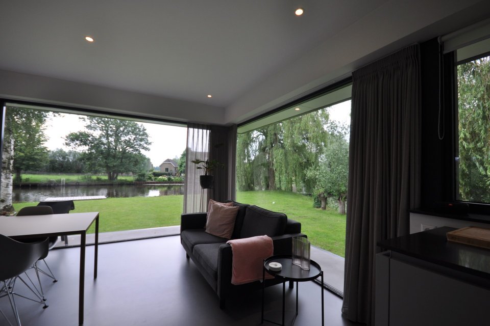 Lichte leefruimte met hoekramen en schuifpui naar de tuin &ndash; licht en zicht in architectuur door architect Oud-Alblas.
