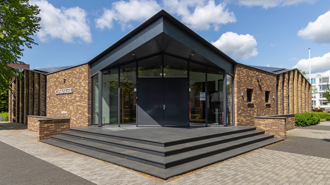 Entree van de gemoderniseerde Ichthuskerk met baksteenarchitectuur en glazen gevel &ndash; duurzaam en eigentijds ontwerp door architect Oud-Alblas.