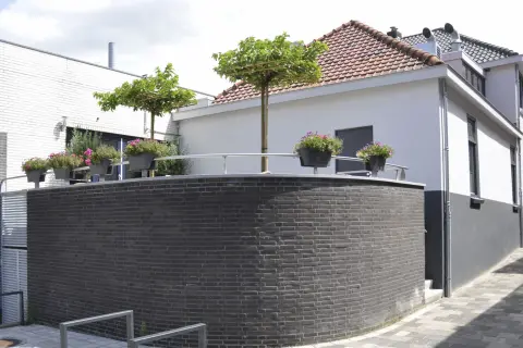 Renovatie van horecapand met gemetselde plint, witte gevel en verhoogd terras &ndash; project door Bongers Architecten.