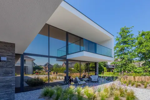 Strakke moderne villa met grote glasgevel, overstekend balkon en minimalistisch design &ndash; architect omgeving Dordrecht