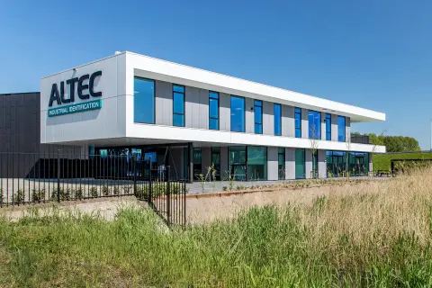 Modern bedrijfspand van Altec in Papendrecht met witte gevelpanelen, blauwe glasstroken en strakke belijning &ndash; ontwerp Bongers Architecten