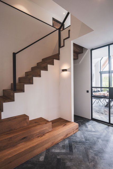 Maatwerk houten trap met stalen leuning en visgraatvloer in moderne woning &ndash; ontwerp door architectenbureau in Zuid-Holland.