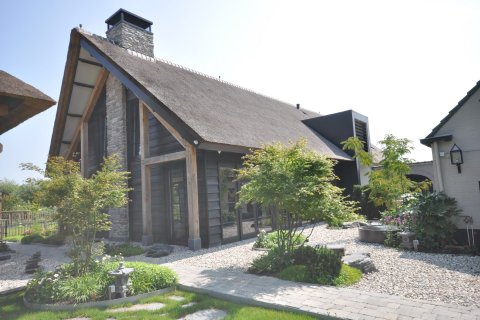 Verbouwing van boerderij met rieten kap, natuurstenen gevel en houten constructie &ndash; project door Bongers Architecten