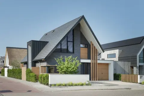 Moderne woning met donkere gevelbekleding, houten details en hoge kap &ndash; compact en stijlvol ontwerp door Bongers Architecten
