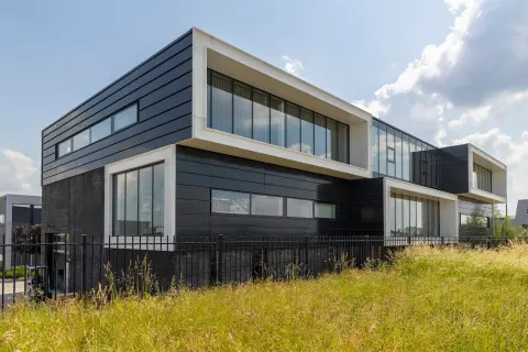 Architect voor bedrijfsunits met moderne gevelcompositie, grote glasvlakken en strakke witte kaders &ndash; bedrijfspand ontwerpen met uitstraling.