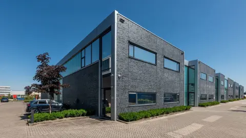 Modern bedrijfsverzamelgebouw met strakke baksteenarchitectuur, verticale glasstroken en functioneel bedrijfspand ontwerpen