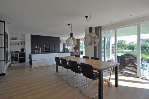 Ruime woonkeuken met openslaande deuren naar tuin in eigentijdse woning &ndash; ontworpen door architect Oud-Alblas