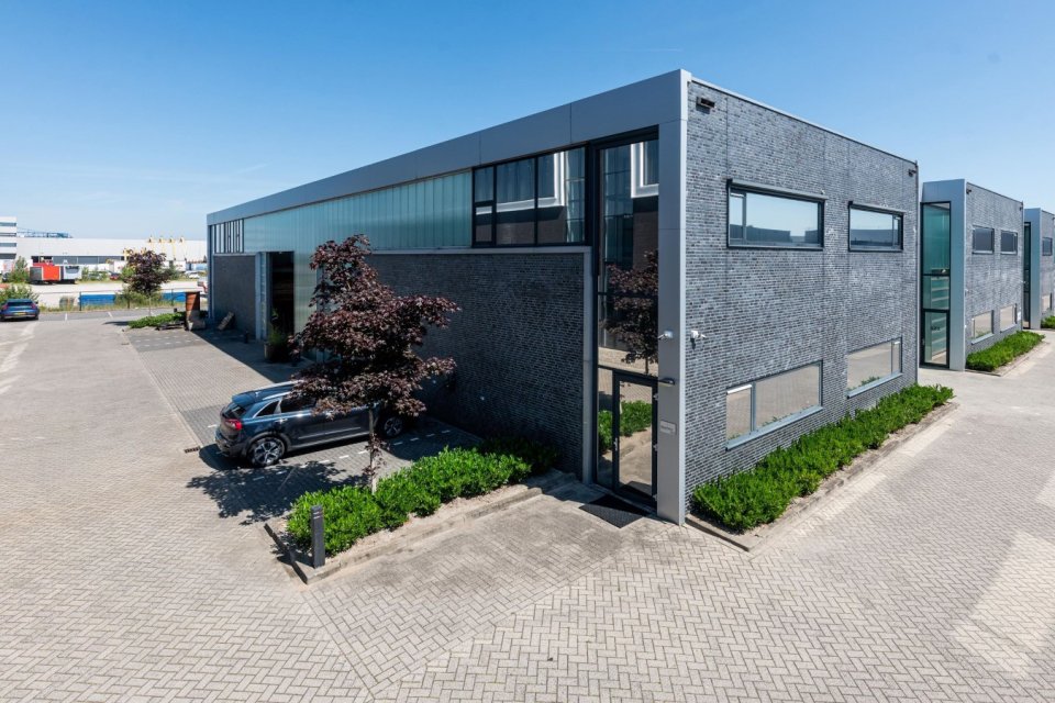Strak bedrijfsverzamelgebouw met donkere baksteengevel, glasstroken en hoekentree &ndash; eigentijds bedrijfspand ontwerpen.