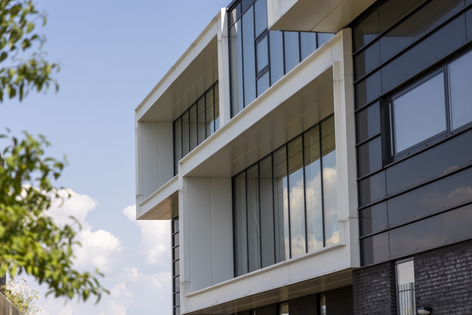 Architect voor bedrijfsunits met verdiepte witte kaders, grote glasvlakken en strakke gevelbekleding &ndash; bedrijfspand ontwerpen met licht en zicht.