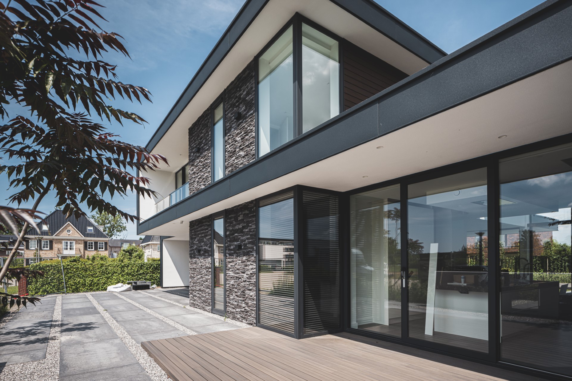 Moderne villa met natuurstenen gevel, grote glaspartijen en minimalistische overstekken &ndash; ontwerp Bongers Architecten, Oud-Alblas